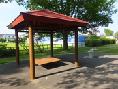 公園内の休憩施設の写真。腰かける場所は低い位置にある。