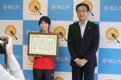 写真:帯広市民栄誉賞を持つ長原選手と市長の記念撮影