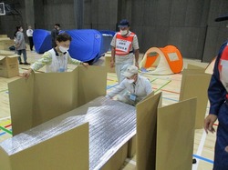 写真:地域防災訓練で居住スペースを作る参加者