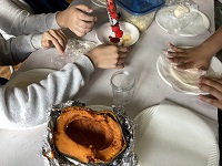 ピザ生地を延ばしトッピングする児童たち