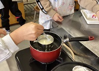 熱した豆乳に、にがりを入れて混ぜている